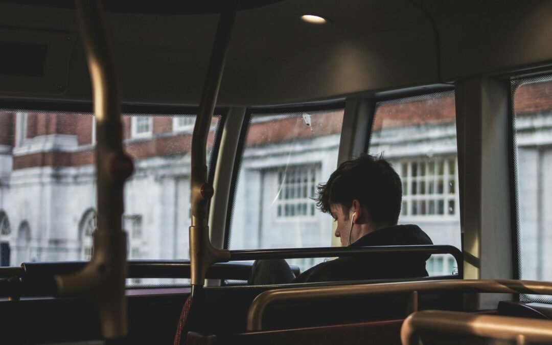 man inside bus using earphones